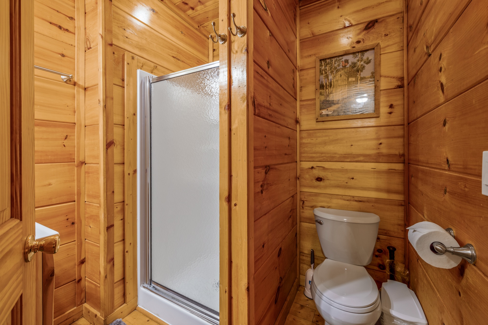 Basement bathroom at Bearadise with a glass shower stall and a rustic outhouse print